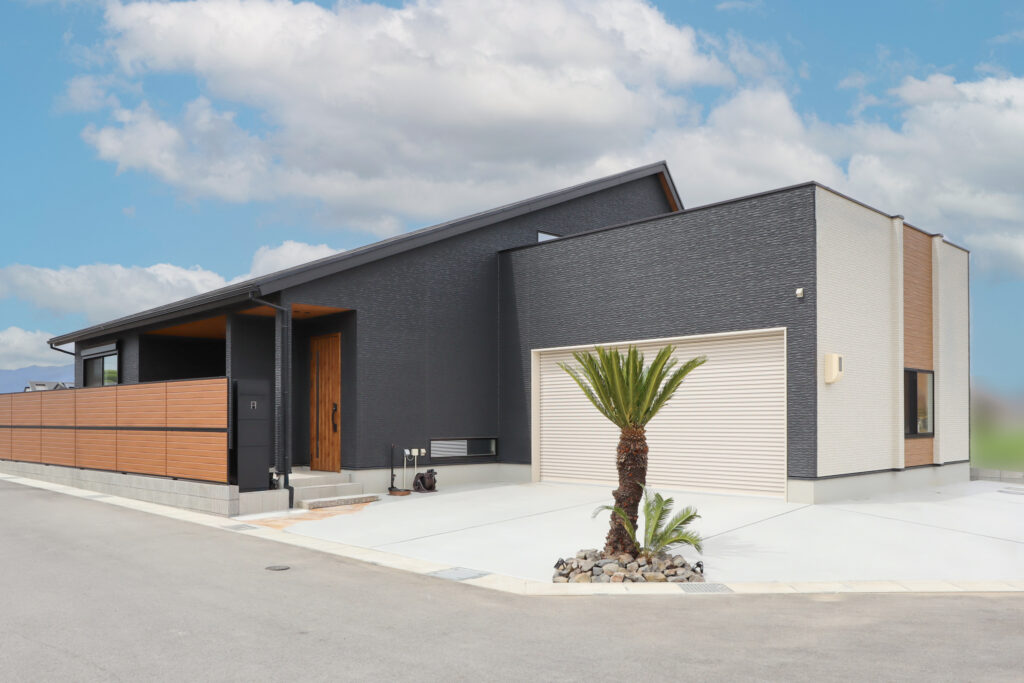 重厚感のあるブラックに木目調のアクセントを合わせたオシャレな平屋の外観です。